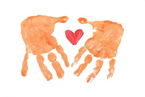 A painting of 2 orange hands with a red heart in the middle.